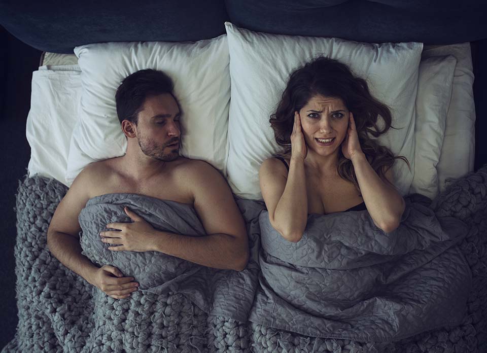 woman has difficulty falling asleep due to snore noise of the boyfriend